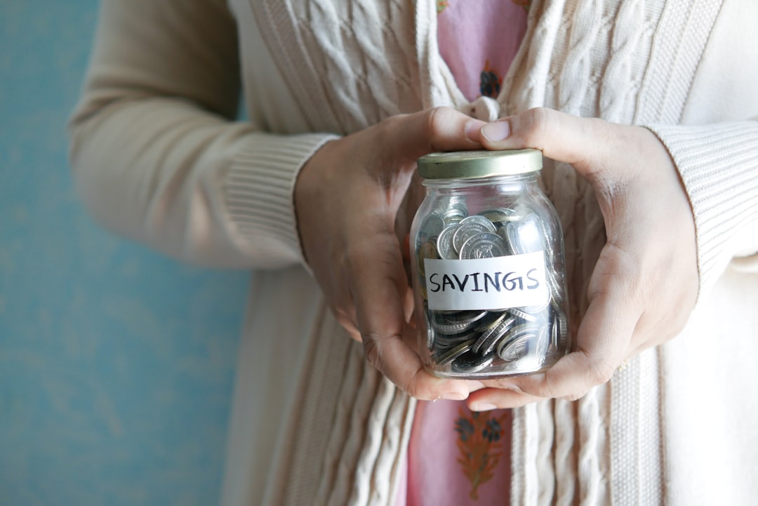 a-woman-holding-a-jar-with-savings-written-on-it-yiifniekkyi